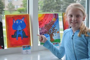 Student Leadership Council student Zoe proudly points out her creation on display at Liberty Middle School in Canton, Michigan.